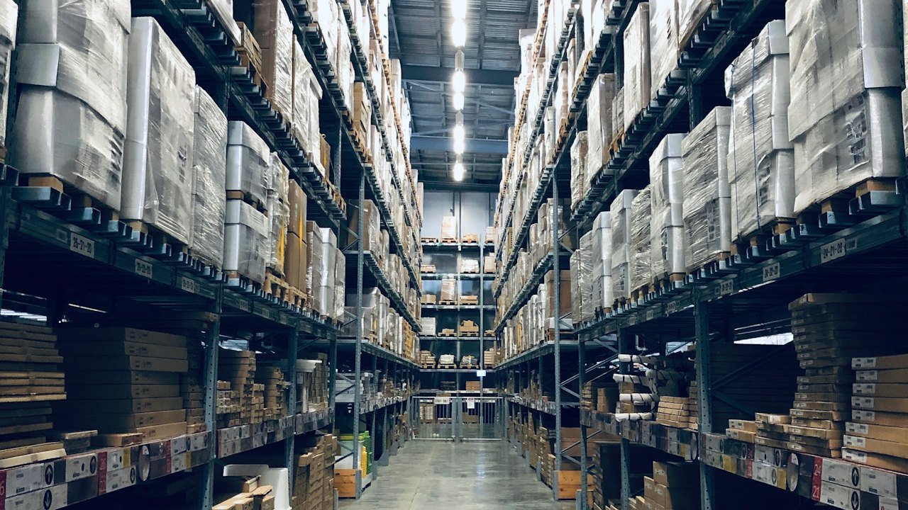 Warehouse aisle with tall racks of stored goods